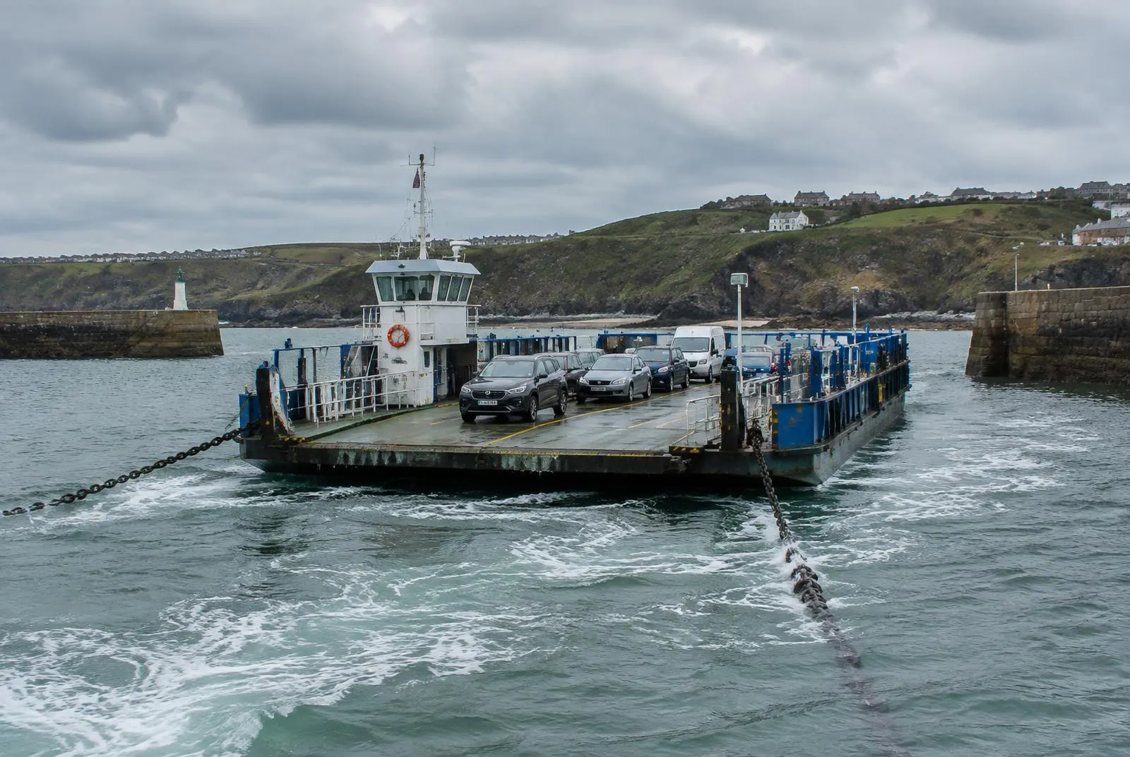 Illustrative view of a vehicle chain ferry hauling itself across a harbour entrance